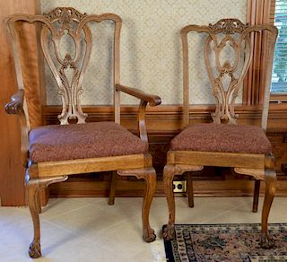 Set of eight oak Chippendale style dining chairs with open work back, slip seats, and claw feet including two armchairs and s