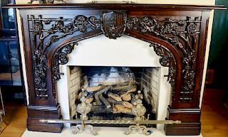 Walnut carved mantle with twig and floral three dimensional carving with center shield. ht. 51in., wd. 72in., opening: ht. 41