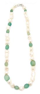 A Baroque Pearl and Carved Green Beaded Necklace Length 28 inches.