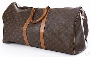 Louis Vuitton monogrammed luggage bag.