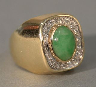 14 karat gold ring set with green jade surrounded by diamonds.
