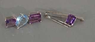 Two custom gold pins, one set with two amethyst and one blue stone, other set with one amethyst.