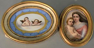 Two oval porcelain hand painted plaques, one with angels in the clouds and the other mother and child.