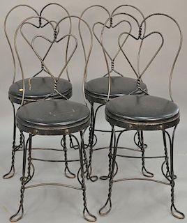 Set of four ice cream side chairs with bent iron heart shaped backs.