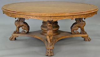 Reproduction oak round table with carved top and carved griffin base, ht. 31in., dia. 80in. Provenance: Property from the Est