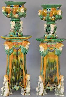 Four piece lot containing pair of Majolica stands and pair of urns, all with putti faces, 20th century. Total ht. 60in. and 5