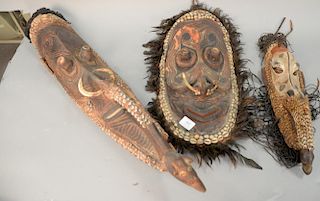 Group of three African masks with horns and inlaid shells. ht. 20in., 20 1/2in., & 34in.