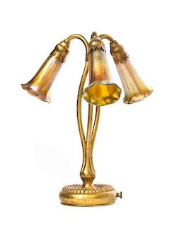 A Tiffany Studios Dore Bronze and Gold Favrile Glass Three-Light Lily Table Lamp, Height overall 12 3/4 inches.