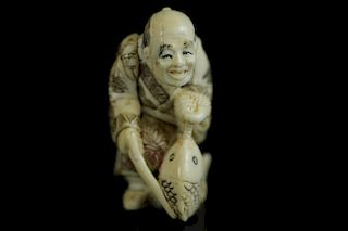 Vintage Netsuke carving of a man carrying a fish