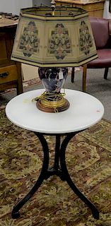 Two piece lot to include an iron parlor table with white penorcelain top (ht. 30in., dia. 24in.), and a marble lamp with tin 