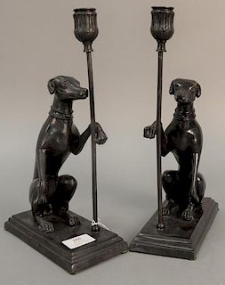 Pair of Maitland Smith bronze dog candle holders having seated dog with paw up holding candlestick, ht. 13in., wd. 7 1/2in.