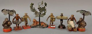 Group of eight figural candle holders including pair of painted metal and brass monkey candle holders, bronze monkey card hol