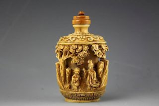 Chinese snuff bottle with sandalwood stopper. Bone carved frieze of figures in a garden. Qianlong mark