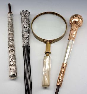 Three ornate parasol handles & magnifier