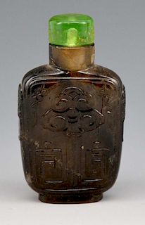 Chinese carved hard stone snuff bottle with green top