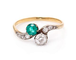 An Edwardian Platinum Topped Gold, Emerald and Diamond Toi et Moi Ring, 1.30 dwts.