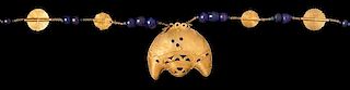 * An Akan Gold Alloy, Metal Alloy, Glass Bead and Crescent Pendant/Necklace, CÃ™te d'Ivoire/Ghana, strung with numerous ro