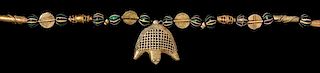 * An Akan Gold Alloy, Metal Alloy, Glass and Crocodile Pendant/Necklace, CÃ™te d'Ivoire/Ghana, strung with numerous round 