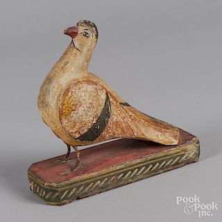 Carved and painted bird on a platform