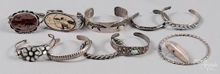 Ten Native American silver and stone bracelets.