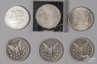 Six Morgan silver dollars.