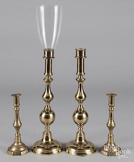 Two pairs of brass candlesticks and a shade