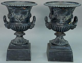 Pair of iron urns with handles on bases.   height 34 1/2 inches, top diameter 22 inches