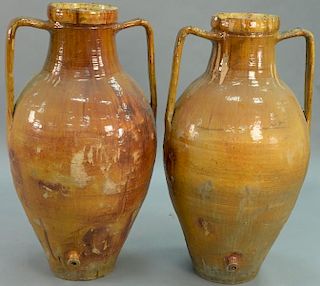 Pair of large earthenware vessels with handles (missing bung) with amber glaze (rim chips).   height 49 inches  Provenance: F