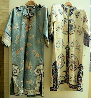 Two silk embroidered robes including one white with embroidered blue flower and fine border, flaming clouds, and six round pa