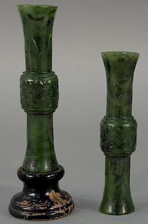 Pair of Chinese spinach jade beaker vases, each having archaic bronze and fluted beaker form (gu), and carvings, both on wood