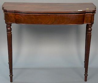 Sheraton mahogany games table with shaped top over conforming skirt, set on turned and fluted legs, circa 1830. 
height 30 in