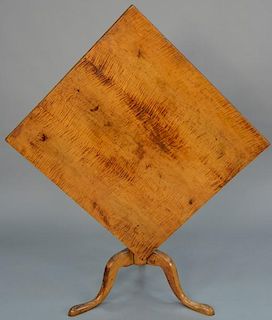 Federal maple and tiger maple tip table with square top on urn turned shaft ending on tripod base.   height 27 inches, top: 2
