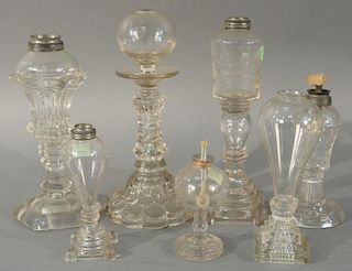 Seven piece lot of flint and sandwich glass oil lamps. 
heights 4 1/2 inches to 10 inches