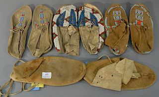 Four pairs of moccasins, three with beadwork (bottom as is).lengths 10 1/2 inches to 12 1/2 inchesProvenance: From the Estate