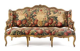* A Louis XV Giltwood Canape a Oreilles Height 45 1/8 x width 76 x depth 25 1/2 inches.