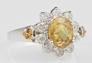 Lady's 14K White Gold Floriform Dinner Ring, with a central oval 2.25 carat yellow sapphire, atop a border of round diamonds,