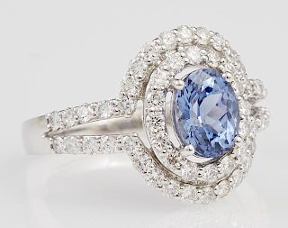 Lady's Platinum Dinner Ring, with an oval 1.61 carat blue sapphire, atop two concentric graduated borders of round diamonds, 