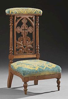 French Carved Walnut Prie Dieu, 19th c., the upholstered arm rest over a pierced cross back splat, to a bowed seat, on turned
