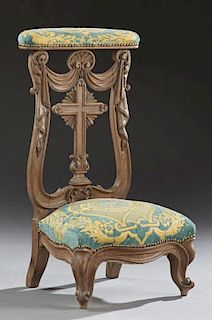 French Louis XV Style Carved Oak Prie Dieu, 19th c., the upholstered arm rest over a garland draped cross back splat, to a bo