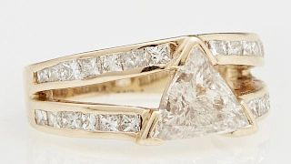 Lady's 14K Yellow Gold Dinner Ring, with a 1.5 carat trillion cut diamond centering a split band mounted with channel set pri