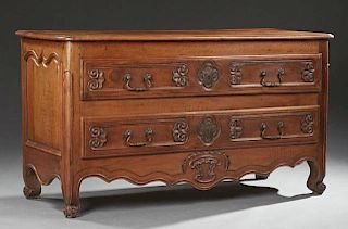 Late French Louis XV Style Carved Walnut Commode, early 19th c., the stepped rounded corner top over two deep drawers, flanke