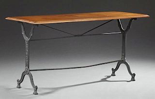 French Carved Oak and Cast Iron Bistro Table, 19th c., the rectangular top on cast iron trestle supports joined by cylindrica