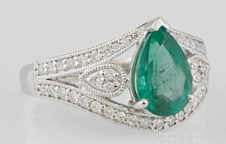 Lady's Platinum Dinner Ring, with a pear shaped 1.89 carat emerald, flanked by round diamonds, atop a wide pierced top with a