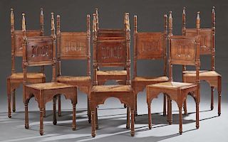 Set of Eight French Provincial Carved Walnut Rush Seat Chairs, early 20th c., the back with tall tapered spires over a linen 