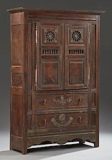 French Provincial Carved Oak Armoire, 19th c., Brittany, the stepped crown over double fielded panel doors with spindled whee