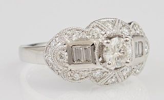 Lady's Platinum Dinner Ring, with a central .51 carat round diamond flanked by diamond baguettes and within a lobed border of