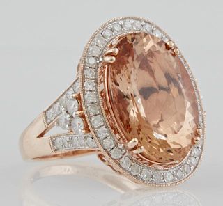 Lady's 14K Rose Gold Dinner Ring, with a 10.91 carat oval morganite, atop a border of round diamonds, the split sides of the 