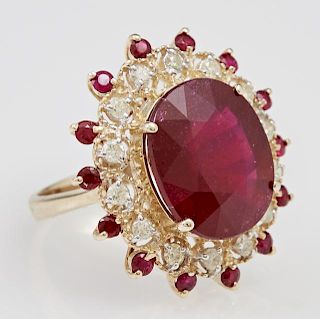 Lady's 14K Yellow Gold Dinner Ring, with a 14.72 carat oval ruby atop a pierced border of round diamonds, separated by an out