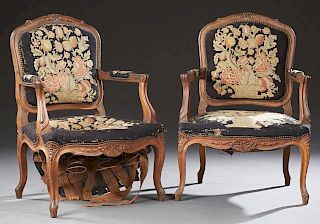 Pair of French Carved Beech Fauteuils, c. 1900, the arched floral carved crests, over shield backs, upholstered arms, and bow