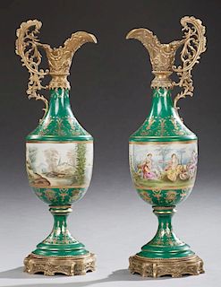 Pair of French Style Gilt Bronze Mounted Porcelain Ewers, late 20th c., with ornate pierced bronze spouts and handles, over a